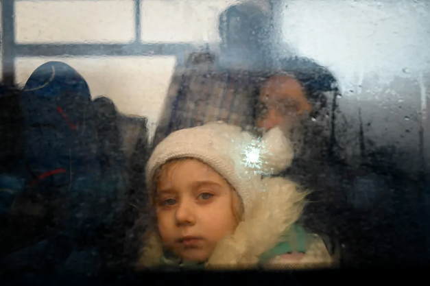 Une fillette dans un bus évacuant des réfugiés ukrainiens vers la Moldavie une semaine après le début du conflit. Photo : Nikolay Doychinov.