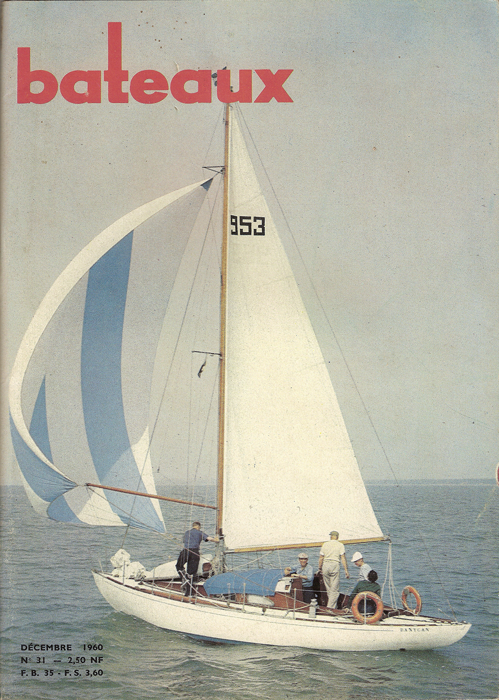 Revue Bateaux n° 31 de décembre 1960 [107] – première de couverture. Photo : P. Groult, prise lors de Cowes-La Corogne – Guy Tabarly debout et vu de dos en tenue claire dans le cockpit.